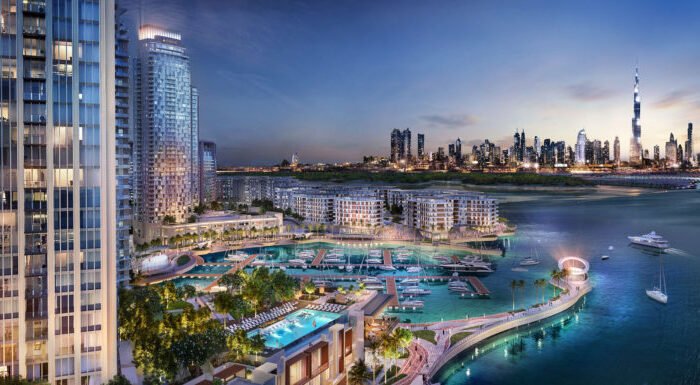 Luxury waterfront marina community with illuminated towers, yachts, landscaped promenades and Dubai skyline at night views