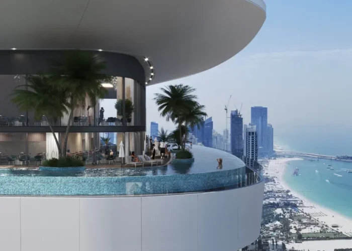Luxury infinity pool terrace with palm trees, curved architecture and panoramic Dubai skyline and beach views at sunset