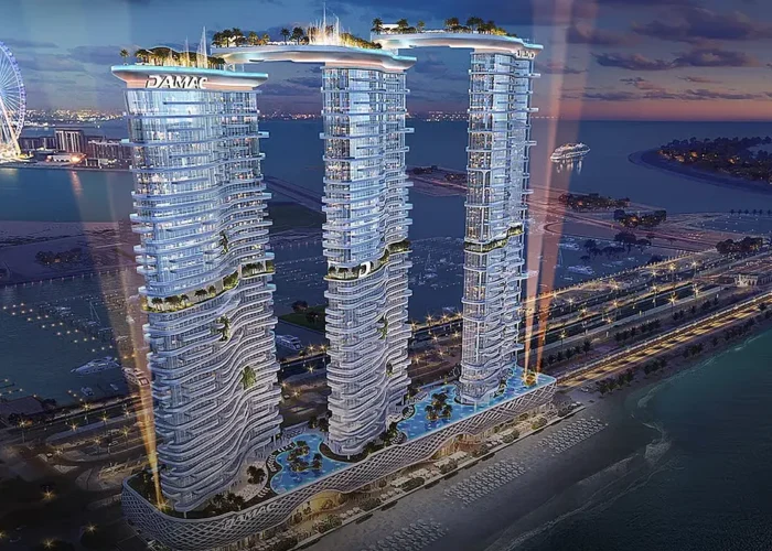 Luxury DAMAC waterfront towers at night with illuminated facades, rooftop amenities, sea views and premium residences