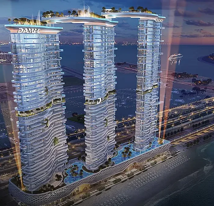 Luxury DAMAC waterfront towers at night with illuminated facades, rooftop amenities, sea views and premium residences