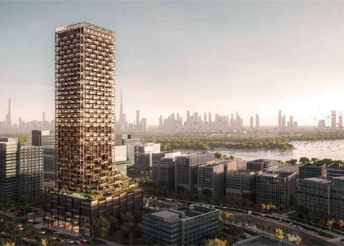 Luxury high-rise tower with modern facade overlooking waterfront, green surroundings and expansive city skyline at sunset